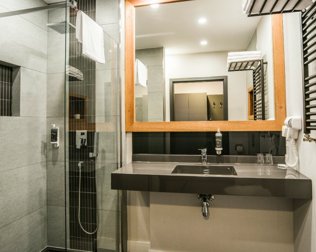 W łazienkach: prysznic, suszarka, szlafrok, komplet ręczników i kosmetyków