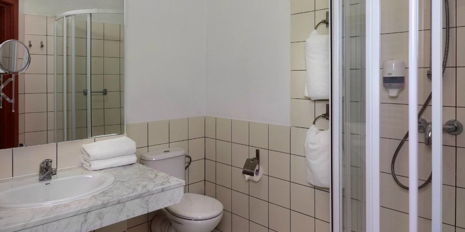 W łazience jest kabina prysznicowa i suszarka do włosów