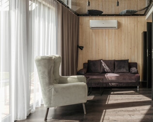 W domku jest przestronny klimatyzowany salon z sofą i odrębna sypialnia